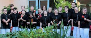 Grupa osób w czarnych koszulkach z instrumentami pekrusyjnymi