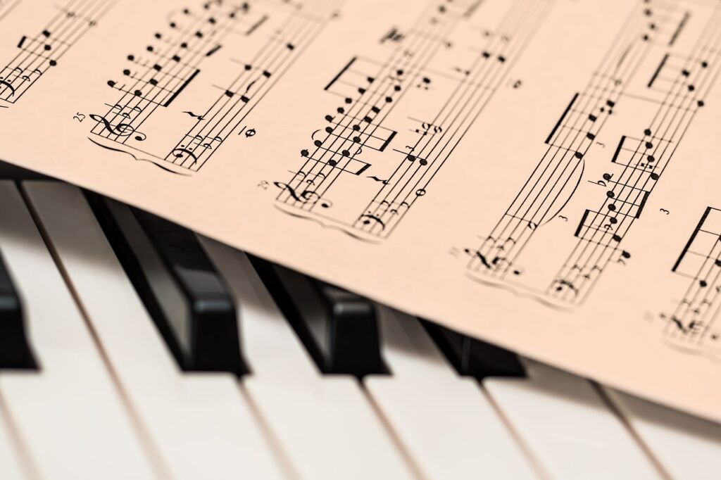 Kartka z wydrukowanym zapisem nutowym leżąca na klawiaturze pianina
